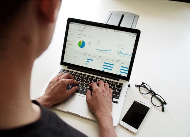 Person typing on a laptop showing charts from an analysis