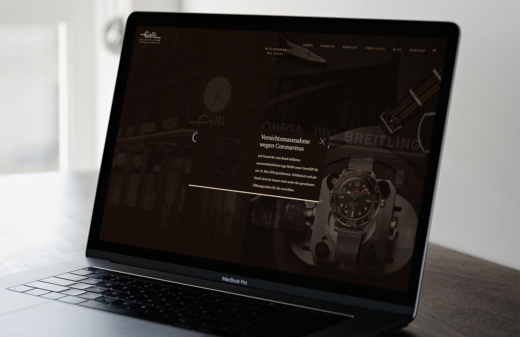 Laptop showing the Galli website with the pop-up «Vorsichtsmassnahme wegen Coronavirus»