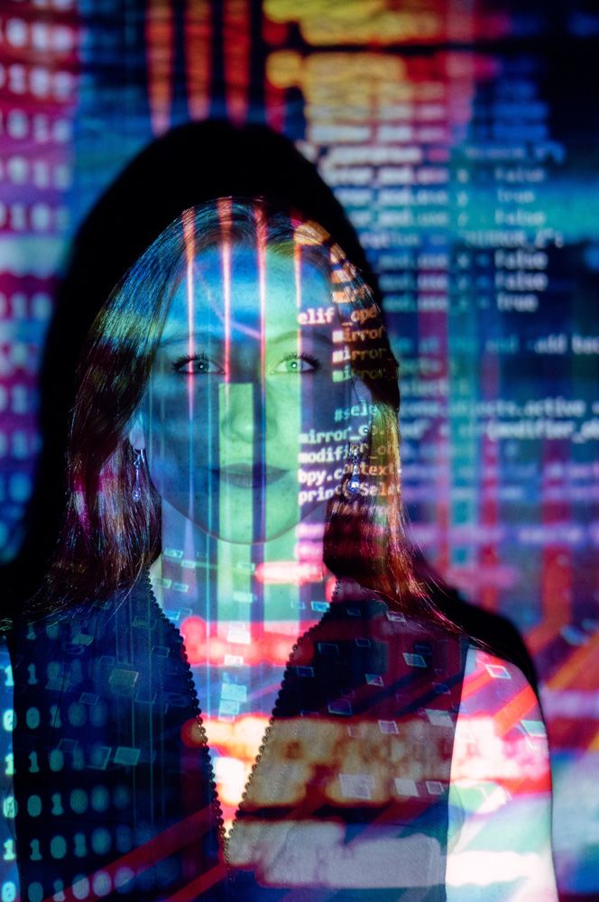 Face of a woman with lines of code and data projected onto it