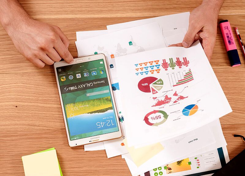Tablet and printed charts analysing a target group on a table