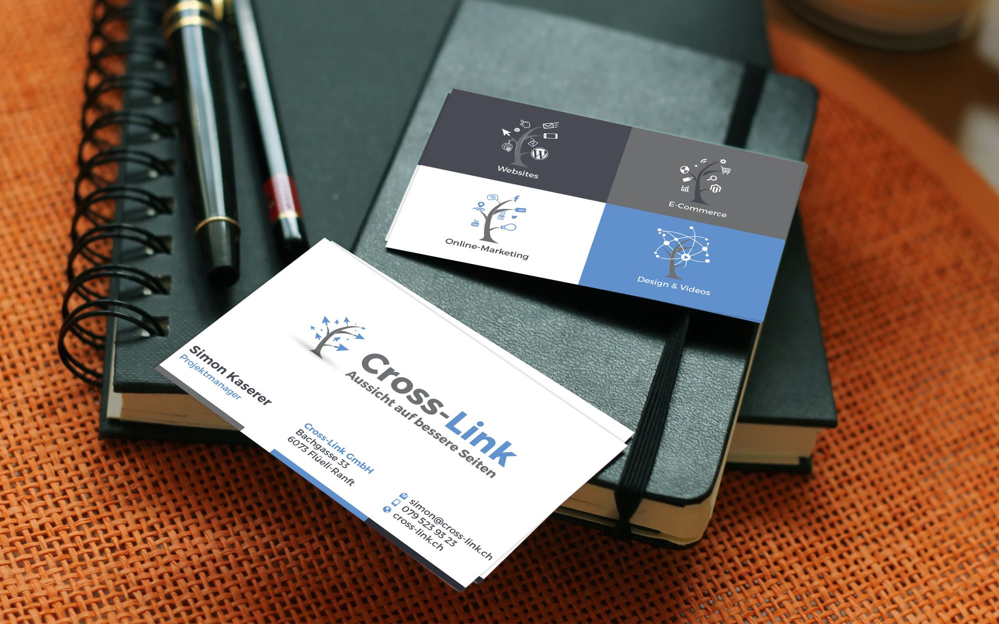 Business card of Cross-Link GmbH with the tree logo, behind it the back with the 4 service areas